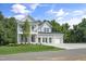 Elegant two-story home featuring a double-decker porch, a green lawn, and a roomy three-car garage at 125 Charlotte Knoll St # 15, Zebulon, NC 27597