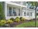 Welcoming front porch with classic rocking chairs, a gray front door, and neat landscaping at 125 Charlotte Knoll St # 15, Zebulon, NC 27597