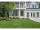 Charming front porch featuring rocking chairs, a gray front door, and well-maintained landscaping at 125 Charlotte Knoll St # 15, Zebulon, NC 27597