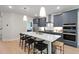 Stylish kitchen with gray cabinets, a quartz countertop island with barstool seating, and stainless steel appliances at 125 Charlotte Knoll St # 15, Zebulon, NC 27597