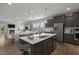 Bright kitchen with gray cabinets, stainless steel appliances, island with sink and seating, and open floor plan at 116 Charlotte Knoll St # 7, Zebulon, NC 27597