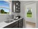 Bright kitchen featuring dark cabinets, a stainless sink, a window with a view, and an espresso machine at 116 Charlotte Knoll St # 7, Zebulon, NC 27597