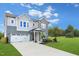 Two-story gray brick and siding house with a three-car garage and landscaping at 148 Charlotte Knoll St # 8, Zebulon, NC 27597