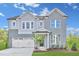 Two-story gray brick and siding house with a three-car garage at 148 Charlotte Knoll St # 8, Zebulon, NC 27597