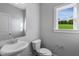Simple bathroom with white vanity, toilet, and large window at 178 Charlotte Knoll St # 9, Zebulon, NC 27597