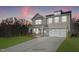 Two-story home with gray siding, white trim, and a two-car garage at dusk at 178 Charlotte Knoll St # 9, Zebulon, NC 27597