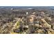 Aerial shot exhibits houses nestled in a wooded area with a distant river, showcasing its serene environment at 1219 Carlton Ave, Burlington, NC 27217