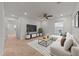 Bright living room features a ceiling fan, sleek white couch, and a modern entertainment center at 1700 Cary Reserve Dr, Cary, NC 27519