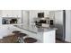 Modern kitchen with white cabinets, gray countertops, and stainless steel appliances at 2326 Sugar Cone Way, Fuquay Varina, NC 27526