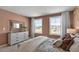 Well-lit bedroom featuring a large dresser and two windows at 2330 Sugar Cone Way, Fuquay Varina, NC 27526