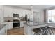 Modern kitchen with white cabinets, gray countertops, and stainless steel appliances at 2330 Sugar Cone Way, Fuquay Varina, NC 27526