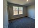 This simple bedroom features soft carpet, neutral colors, and a view of the outdoors at 25 Accord Dr, Youngsville, NC 27596
