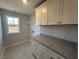 Functional laundry room with granite counters and ample cabinet space for storage at 25 Accord Dr, Youngsville, NC 27596