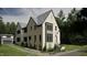 Side view of a two-story house with white brick and gray siding, a gabled roof and attached garage at 2650 Marchmont Street St, Raleigh, NC 27608