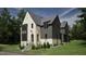 Two-story house with white brick and gray siding, a gabled roof, and landscaping at 2650 Marchmont Street St, Raleigh, NC 27608