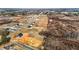 A high-angle aerial shot showcasing a residential area with newly constructed homes surrounded by open fields and sparse woodland at 2995 Faucette Ln, Burlington, NC 27217