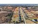 An elevated view of a neighborhood featuring identical houses lining a road and patches of exposed earth and forest at 2995 Faucette Ln, Burlington, NC 27217
