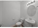 Small, modern half bathroom with a pedestal sink and round mirror at 2995 Faucette Ln, Burlington, NC 27217