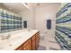 Clean bathroom with a double sink vanity, decorative shower curtain, and tile floors at 30155 Pharr, Chapel Hill, NC 27517