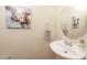 Charming half bathroom with pedestal sink, decorative painting, and round mirror at 30155 Pharr, Chapel Hill, NC 27517