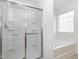 Bright bathroom featuring a glass door shower, soaking tub and large window at 3021 Polanski Dr, Wake Forest, NC 27587