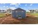 Back exterior of the home with blue siding, windows, and a sliding glass door to the yard at 3615 Nc-62, Burlington, NC 27217
