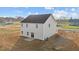 Two-story home with light siding, dark roof, patio, and an unfinished yard at 3649 Nc-62, Burlington, NC 27217