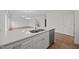 Modern kitchen featuring white cabinets, stainless steel sink, and wood flooring at 3649 Nc-62, Burlington, NC 27217