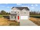 Charming two-story home features a gray exterior, red front door, and attached two-car garage at 3689 Nc 62, Burlington, NC 27217