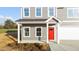 Inviting front porch with red door, white columns, and gray siding, leading to a two-car garage at 3689 Nc 62, Burlington, NC 27217