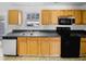 Clean kitchen featuring tile floor, black appliances, wood cabinets, and window at 3810 Chehaw Dr, Raleigh, NC 27610