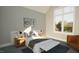 Modern bedroom with large windows, neutral tones, stylish decor, and a comfortable bed with bench at 3813 Peaceful Creek Trl, Zebulon, NC 27597