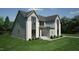 Contemporary two-story home featuring gray siding, brick details, large windows, and a green lawn at 3813 Peaceful Creek Trl, Zebulon, NC 27597