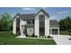 Elegant home with modern design, gray siding, white brick accents, and a well-kept lawn at 3813 Peaceful Creek Trl, Zebulon, NC 27597