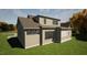 Exterior view of a two-story home showing the architectural design, roofline, and backyard at 3813 Peaceful Creek Trl, Zebulon, NC 27597