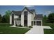 Stylish two-story home with gray siding, brick accents, attached garage, and manicured landscaping at 3813 Peaceful Creek Trl, Zebulon, NC 27597
