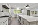 Modern kitchen with white cabinets, large island, and stainless steel appliances at 3813 Peaceful Creek Trl, Zebulon, NC 27597