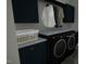 Bright laundry room featuring modern washer and dryer, granite countertops, and ample storage cabinets at 3813 Peaceful Creek Trl, Zebulon, NC 27597