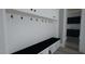 Well-organized mudroom with built-in bench, coat hooks, and storage cabinets, adjacent to the laundry room at 3813 Peaceful Creek Trl, Zebulon, NC 27597