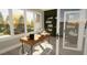 Bright home office with modern desk, large windows with tree views, and ample shelving at 3813 Peaceful Creek Trl, Zebulon, NC 27597