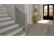 Modern staircase with wood treads, black railings, and a view of the front door and entryway at 3813 Peaceful Creek Trl, Zebulon, NC 27597