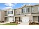 Three-unit townhome building with gray and beige siding, two-car garages, and landscaping at 422 Honeycutt Oaks Dr, Angier, NC 27501