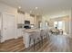 Open kitchen with white cabinets, granite island, and view into dining area at 483 White Birch Ln, Angier, NC 27501