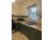 Well-lit kitchen sink with tan countertops, dark green cabinets, stainless steel range and a window view at 494 S Mason St, Coats, NC 27521