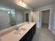 Bright bathroom featuring double sinks with white quartz countertops and a large mirror at 50 Cordoba Dr, Franklinton, NC 27525