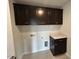 Well-organized laundry room featuring dark cabinets and neutral countertops, perfect for efficient chores at 50 Cordoba Dr, Franklinton, NC 27525