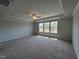 Large main bedroom with carpet, multiple windows, and tray ceiling at 50 Cordoba Dr, Franklinton, NC 27525