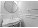 Small bathroom with pedestal sink and round mirror at 520 S Bloodworth St, Raleigh, NC 27601