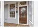 Close-up of the front door with a sidelight, lantern, and porch with wood floors and a white column at 520 S Bloodworth St, Raleigh, NC 27601