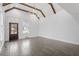 Bright living room with vaulted ceiling, exposed wood beams, chandelier, hardwood floors, and large windows at 520 S Bloodworth St, Raleigh, NC 27601